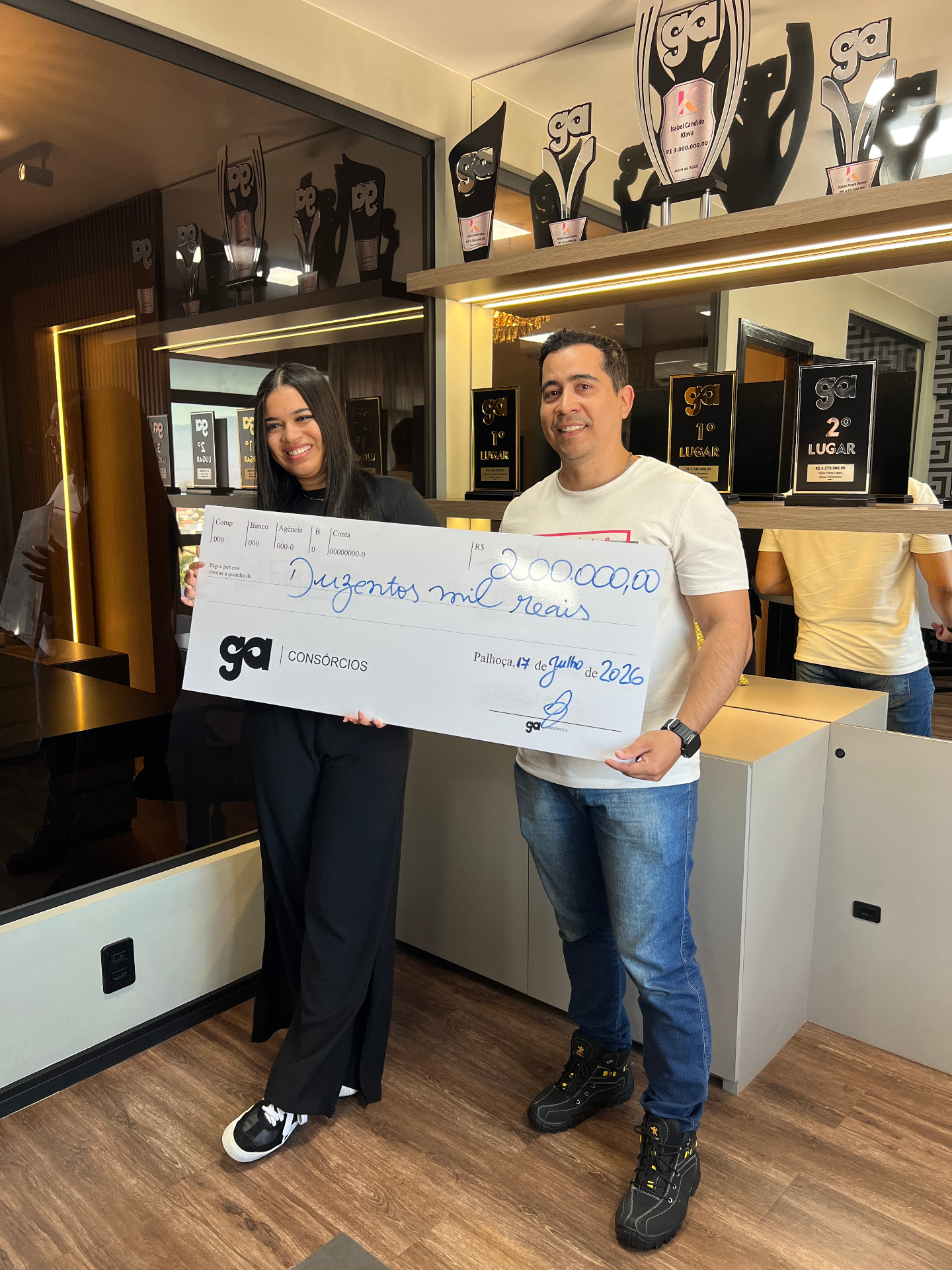 Cliente Klava recebendo cheque de conquista em Palhoça/SC